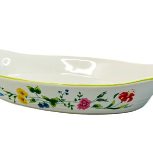 Puede incluir: Plato para hornear ovalado de cerámica blanca con borde verde y diseño floral. El plato tiene dos asas a los lados.