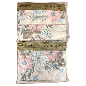 May include: Two sealed packages of Springmaid Grace Kelly queen-size fitted sheets. The sheets feature a floral pattern with pink, blue, and brown flowers on a cream background. The packaging includes the Springmaid and Grace Kelly logos.