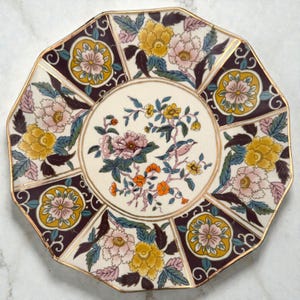 May include: A set of three ceramic mugs with a speckled, matte finish. The mugs are in shades of cream, light gray, and dark gray. Each mug has a simple, minimalist design and a rounded handle.