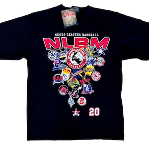 May include: Black t-shirt with the text "NEGRO LEAGUES BASEBALL" and "NLBM" in red and white. The shirt showcases various team logos and the number 20. A tag is attached at the top.