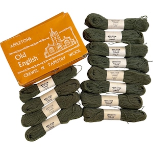 May include: An orange box with the text "APPLETONS Old English CREWEL & TAPESTRY WOOL" and a church illustration, next to several spools of green yarn. Each spool has a label that reads "APPLETON BROS LTD LONDON".