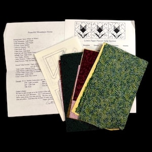 May include: A quilting kit with fabric swatches in green, maroon, and pink, along with pattern instructions. The instructions are titled "Peaceful Mountain Home" and "Lower Paper Pieced Tulip Section."
