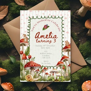 May include: An invitation card with a whimsical design featuring red and white mushroom illustrations, a snail, and a mouse. The text reads "Amelia turning 3" with event details. The card is surrounded by a green border and a brown envelope.