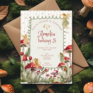 May include: A whimsical invitation card featuring a fairy theme. The card has a cream background with a decorative frame and text that reads "You're Invited to Celebrate Amelia turning 3". The card is adorned with illustrations of fairies and red mushrooms.
