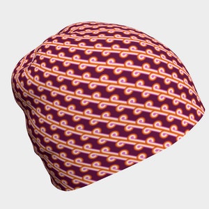 May include: A burgundy beanie with a repeating pattern of pink and orange curved lines.