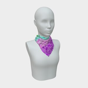 May include: A vibrant, geometric patterned scarf in shades of purple, pink, and teal. The scarf is displayed on a white mannequin, showcasing its triangular shape and colorful design. The scarf is a fashion accessory.