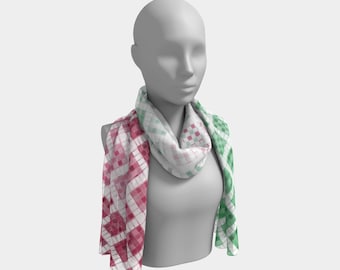 May include: A lightweight scarf with a geometric pattern in shades of pink, white, and green. The scarf is draped around a mannequin, showcasing its design and texture. The pattern consists of small squares arranged in a grid.