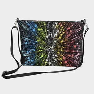 May include: Black crossbody bag with a colourful burst pattern. The design features a radial explosion of white, yellow, blue, and pink dots and lines against a black background. The bag has a black adjustable strap and silver-tone hardware.