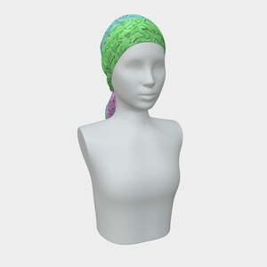 May include: A colorful headscarf on a mannequin. The headscarf features a vibrant pattern of green, blue, and pink hues. The fabric is draped over the mannequin's head and tied at the back, showcasing the design and style of the accessory.