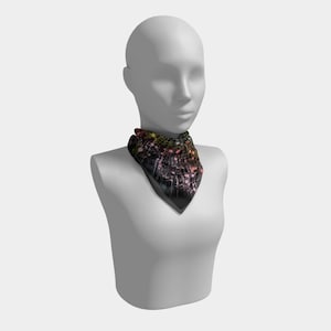 May include: A black bandana scarf with a vibrant, abstract pattern. The scarf is displayed on a mannequin. The design features splashes of pink, yellow, and green against a dark backdrop. The scarf is made of a soft material.