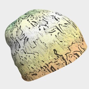 Peut inclure: Un bonnet avec un motif abstrait unique. Le chapeau présente un mélange de couleurs, notamment du jaune, du vert et de l'orange, avec des formes noires irrégulières réparties sur la surface. Un accessoire doux et confortable.