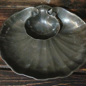 May include: A silver serving dish shaped like a seashell with a smaller seashell-shaped bowl inside.