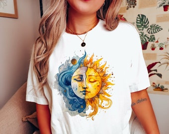 Op de afbeelding: Wit T-shirt met een aquarel-illustratie van een zon en maan met gezichten. De zon is geel en de maan is blauw.