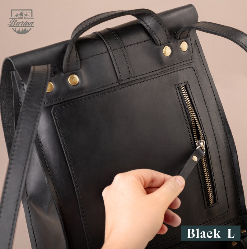 May include: Black leather backpack with a zippered pocket on the back. The backpack has a top handle and adjustable straps. The text "Black L" is visible at the bottom of the image.