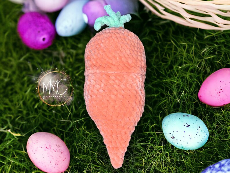 May include: A plush carrot-shaped Easter basket with a green top, surrounded by colorful Easter eggs on a bed of green grass.
