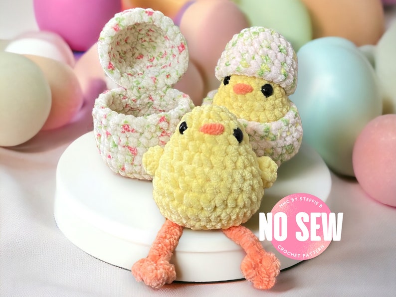 May include: Two crocheted yellow chicks, one sitting in a crocheted floral egg, and the other sitting on a white surface. A pink circle with the text "NO SEW CROCHET PATTERN" is in the foreground.