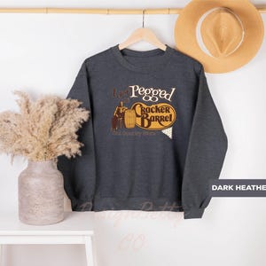 a sweater hanging on a wall next to a plant