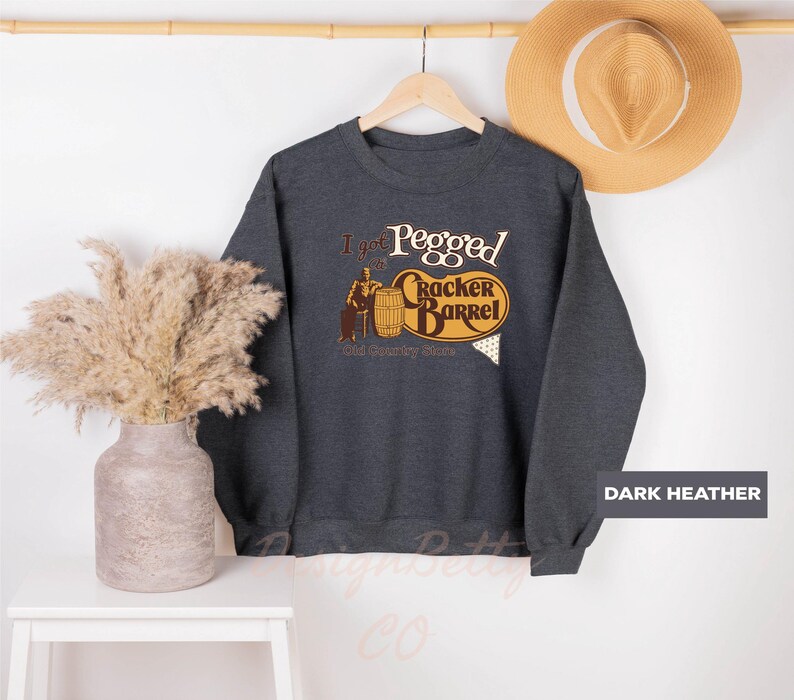 a sweater hanging on a wall next to a plant