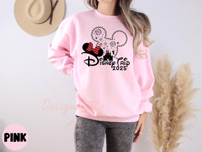 a woman wearing a pink sweatshirt with minnie mouse on it