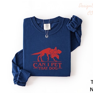 A navy blue long-sleeved t-shirt with a red graphic design and text printed on it.