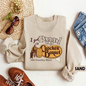 a sweater with the words, i got people at cracker barrel, and a