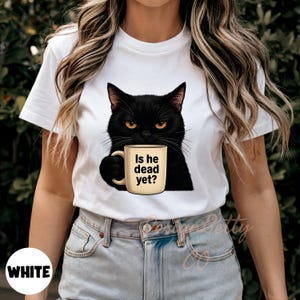 May include: White t-shirt with a black cat holding a coffee mug that says "Is he dead yet?"