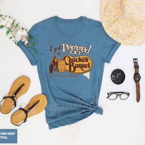 a t - shirt that says i'm pregnant and a hat, sunglasses,
