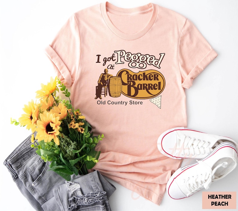 a pink t - shirt that says, i get people to crack barrel old country