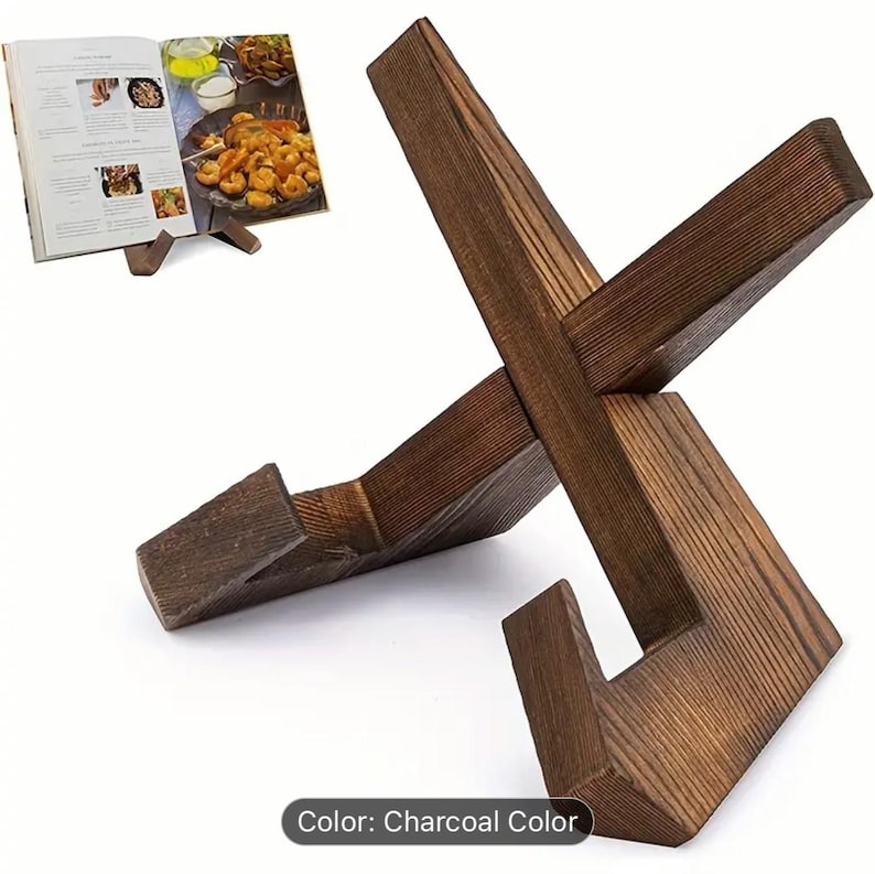 May include: Charcoal-colored wooden cookbook stand with an X-shaped design. The stand is holding a cookbook open to a recipe with images of food. The stand is made of wood and has a rustic appearance.