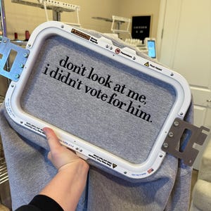 May include: A gray sweatshirt with the text "don't look at me, i didn't vote for him." embroidered on it.