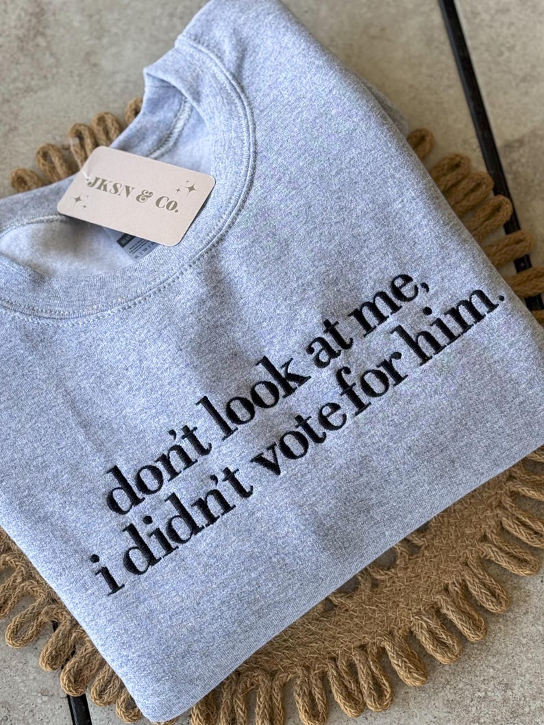 May include: Gray sweatshirt with the text "don't look at me, i didn't vote for him." embroidered in black.