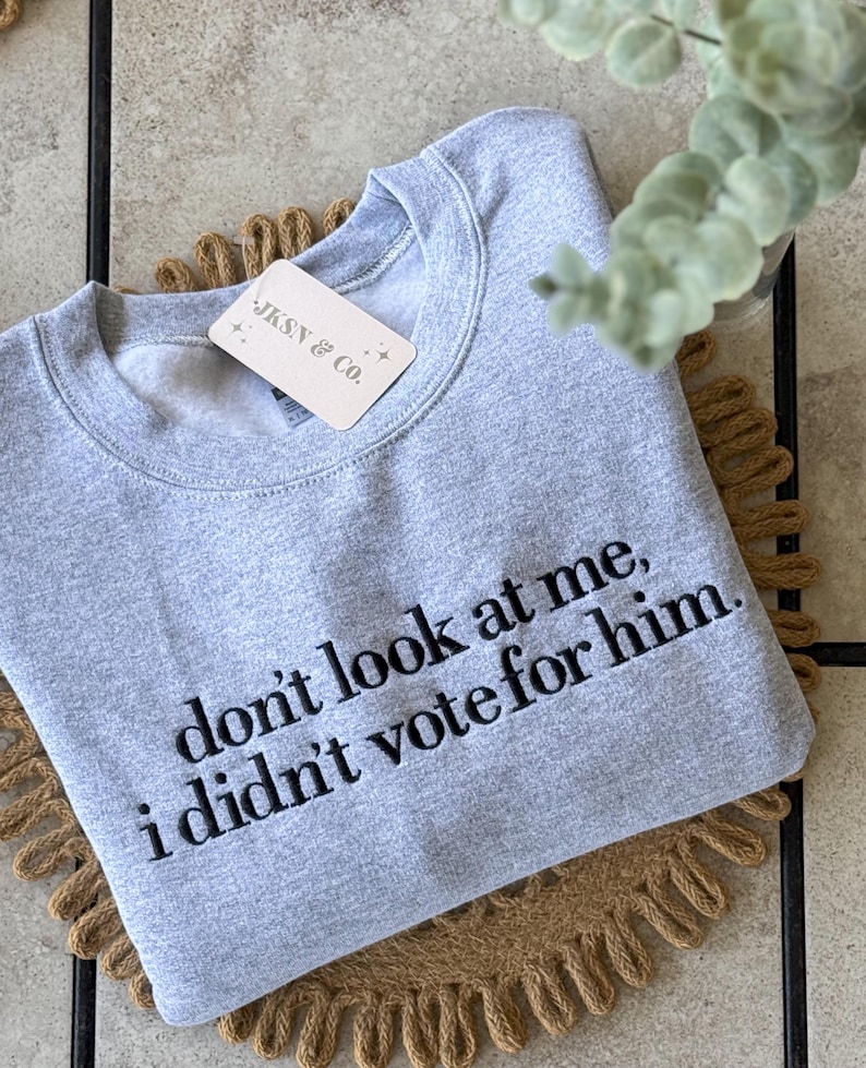 May include: Gray sweatshirt with the text "don't look at me, i didn't vote for him." printed in black.