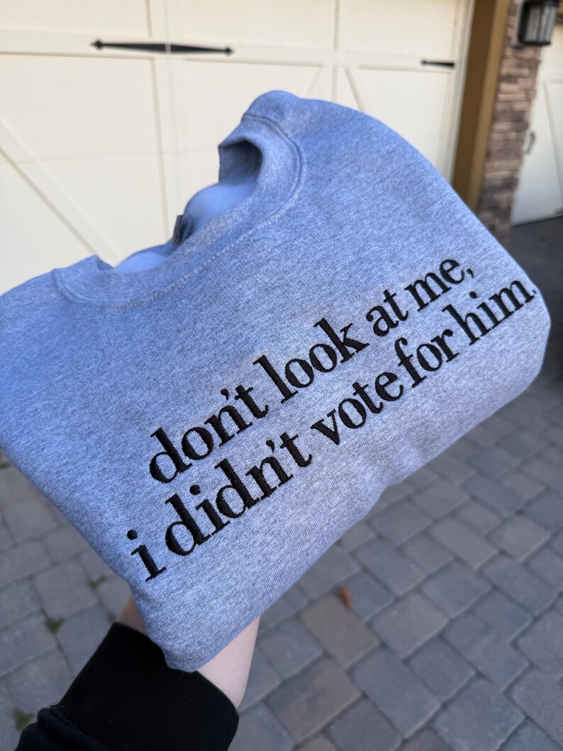 May include: Gray sweatshirt with the text "don't look at me, i didn't vote for him" printed in black.
