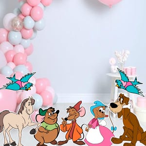 Puede incluir: Un conjunto de recortes de personajes de dibujos animados que incluyen a Cenicienta, Gus, Jaq, el caballo de Cenicienta y dos pájaros azules. Los personajes están parados frente a un fondo de globos rosas y azules.
