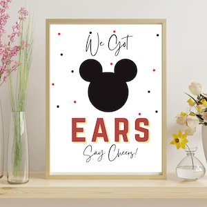 May include: A framed print with a white background features a black Mickey Mouse silhouette and the words "We Got EARS Say Cheers!" in red and black. The print is decorated with red and black dots.