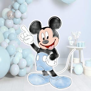 May include: A cutout of Mickey Mouse featuring a black head and ears, a peach-coloured face, and a black torso. The character wears light blue shorts and large light blue shoes with white gloves, pointing one finger upward with a wide smile.