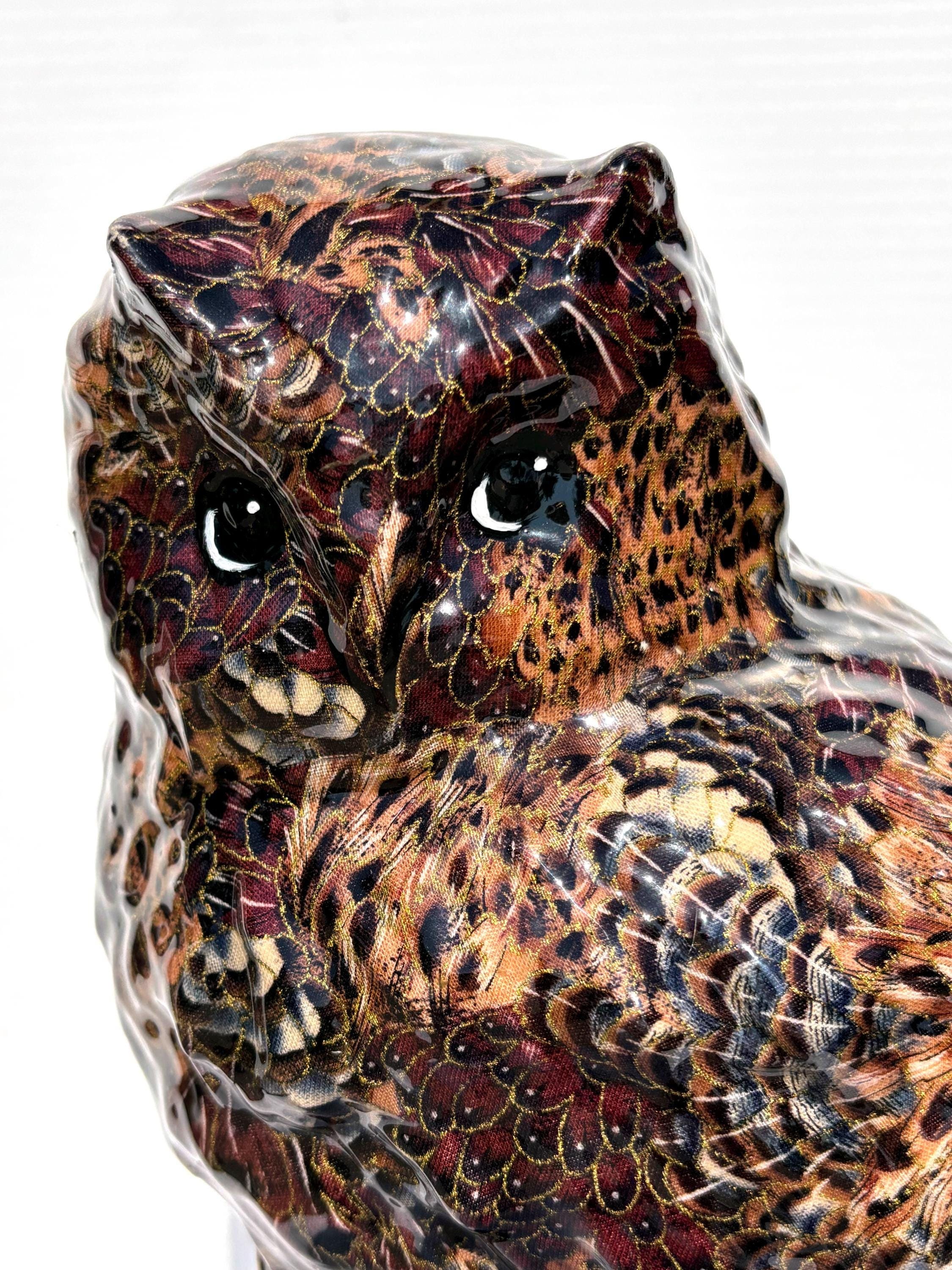 Elegant Large Owl Covered with Brown Feathers Accented with Gold Perched above a Forest of Green Tre
