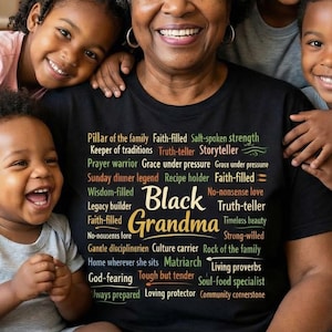 May include: A smiling Black woman wearing a black t-shirt with the words "Black Grandma" and other words printed on it. She is surrounded by four smiling children. The group is sitting on a beige couch.
