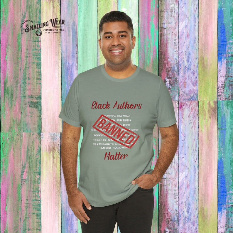 May include: A person wearing a green t-shirt with the text "Black Authors" and a red "Banned" stamp over the list of authors. The text "Matter" is below the list of authors.
