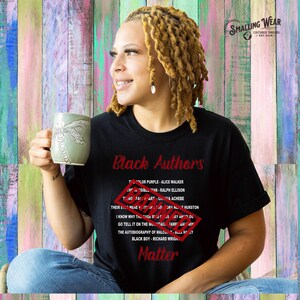 May include: Black t-shirt with the text "Black Authors" in red. The shirt lists the names of several Black authors and their books, including "The Color Purple" by Alice Walker, "The Invisible Man" by Ralph Ellison, "Things Fall Apart" by Chinua Achebe, and "Their Eyes Were Watching God" by Zora Neale Hurston. The text "Black Authors Matter" is also printed in red on the shirt.