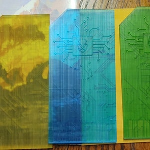 May include: Five rectangular plastic cards with a circuit board design and a small symbol in the center. The cards are black, yellow, blue, green, and orange.