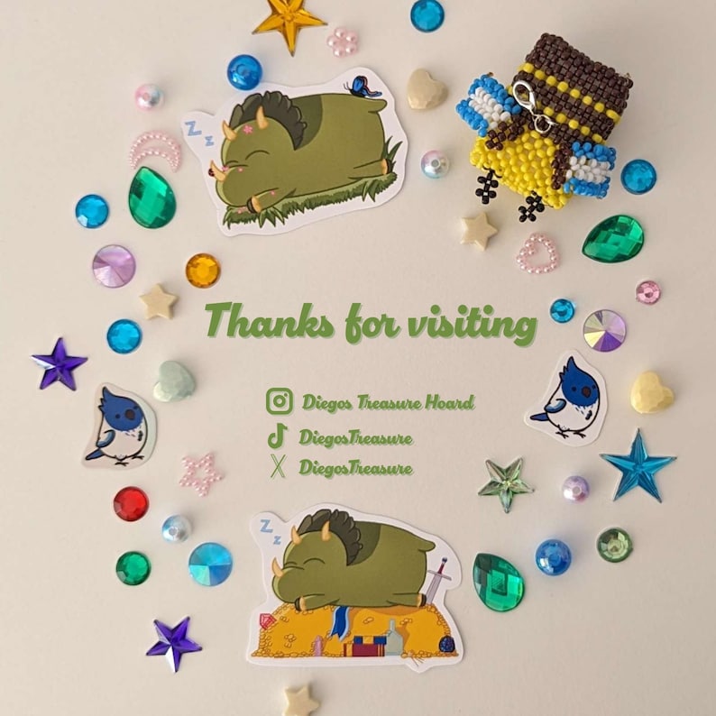 May include: A collection of colorful stickers and embellishments, including stars, gems, and heart shapes, arranged around two cartoon illustrations of a sleeping dinosaur and a beaded bird. The text "Thanks for visiting" is also present.
