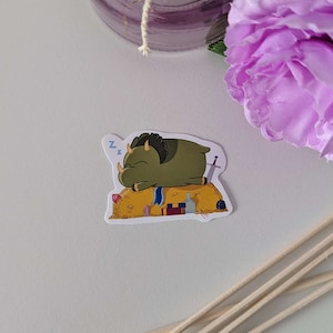 Könnte beinhalten: Ein grüner Cartoon-Dinosaurier schläft auf einem Haufen Goldmünzen, Juwelen und einem Schwert. Der Dinosaurier trägt einen blauen Schal und hat ein Z über seinem Kopf.