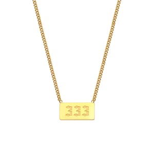 Puede incluir: Collar de cadena dorada con un colgante rectangular que presenta el n&uacute;mero 333 en una fuente g&oacute;tica.
