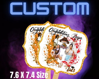 May include: Two custom-designed, 7.6 x 7.4 inch, white fan cutouts with gold glitter trim. The fan cutouts feature a colorful, abstract background with a photo of a person and the text "Congratulations Jaya".