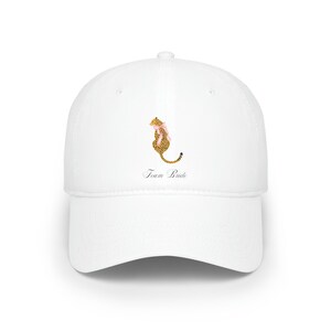 May include: White baseball cap with a cheetah print animal wearing a pink bow and the text "Team Bride" embroidered on the front.