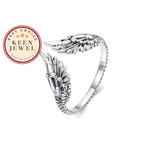 May include: Silver ring featuring a design of two angel wings. The ring is marked with "S925" on the side.