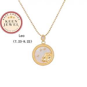 Könnte beinhalten: Goldkette mit einem runden Anhänger, der eine weiße Muschel mit einem goldenen Löwenmotiv und kleinen goldenen Sternen zeigt. Der Anhänger hat einen goldenen Seilrand. Der Text "Leo (7.23-8.22)" befindet sich unterhalb der Kette.
