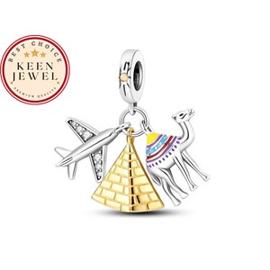 May include: Silver charm with a gold pyramid, a silver airplane with clear crystals, and a colorful camel. The charm is attached to a silver ring.