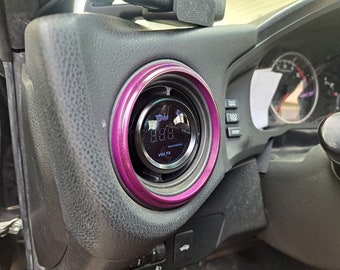 May include: A close-up of a car's dashboard featuring a purple-rimmed gauge displaying "8.88" volts. The gauge has a black face with white lettering and a warning indicator.